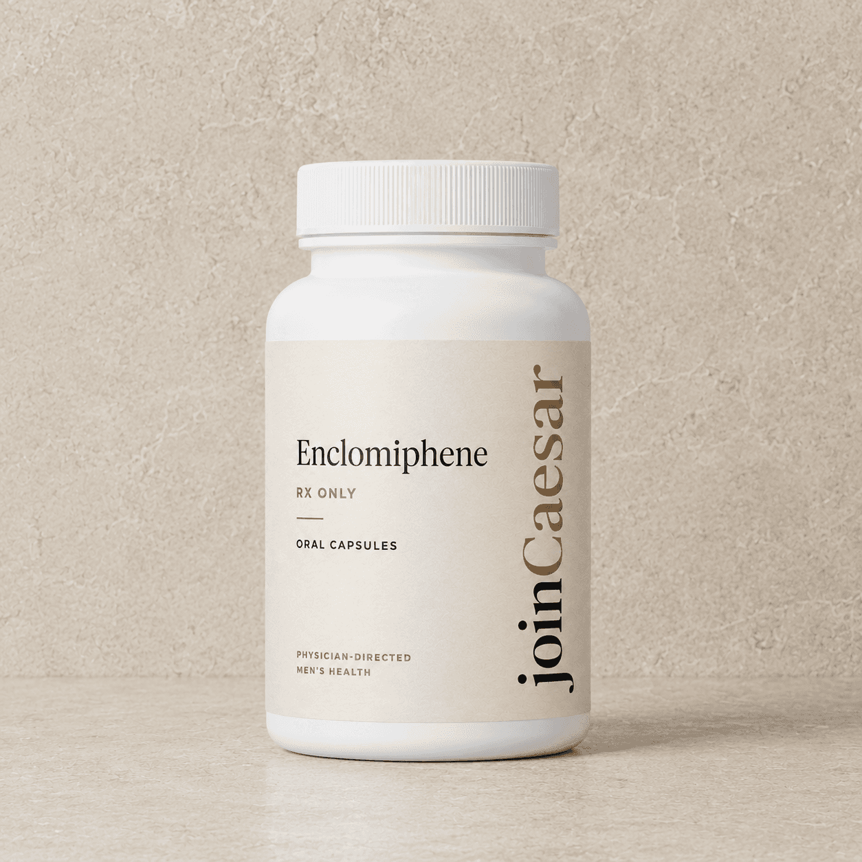 Caesar Enclomiphene oral capsules in a white bottle against a travertine wall